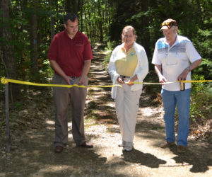 From left: David Seavey, Carrie Kinne, and George Richardson cut the ribbon at the Carl and Barbara Segerstrom Preserve at Squam Creek on Sunday, Aug. 6. The preserve on Westport Island is now open to the public. (Charlotte Boynton Photo)