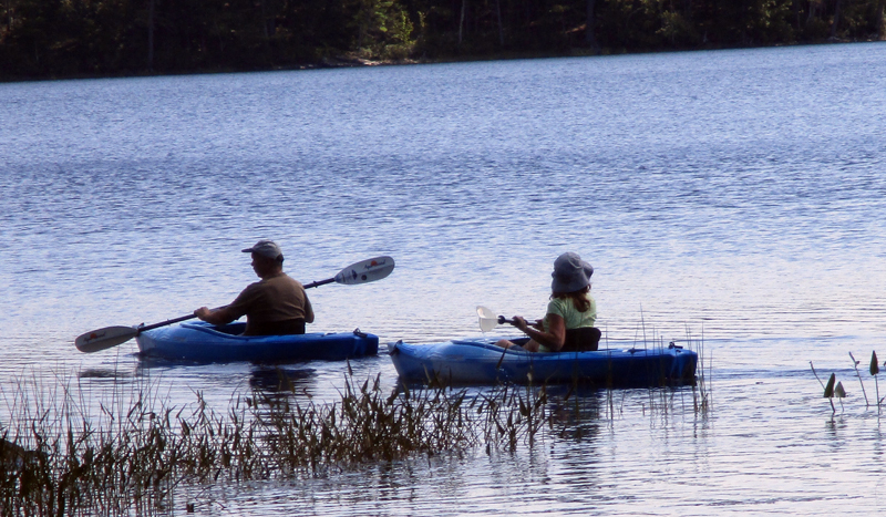 Kayakers on Crystal Lake in Washington enjoy a summer paddle.