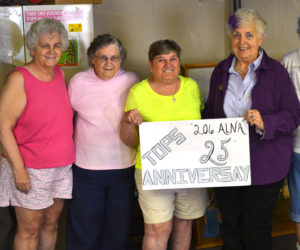 From left: TOPS 206 members Pam Wakelin, Shirley Rice, Virginia Wright, June Caton, Carol Verille, and Ernestine Lincoln hold a sign commemorating the group's 25th anniversary. (Abigail Adams photo)