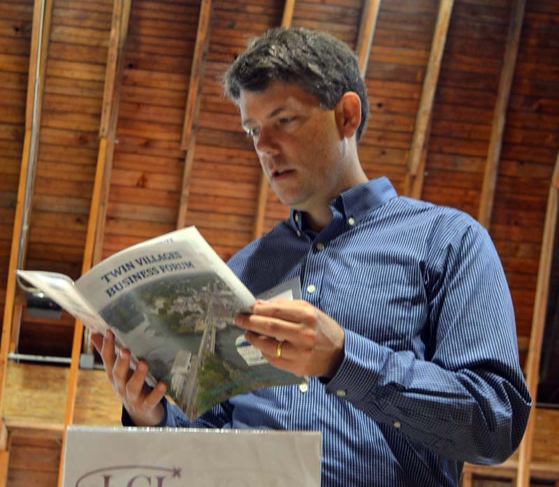Damariscotta River Association Executive Director Steven Hufnagel looks at a Twin Villages Business Forum program during the forum in the Darrows Barn at Round Top Farm on Friday, Sept. 22. (Maia Zewert photo)