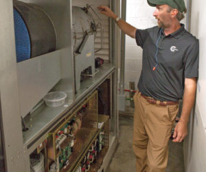 Monhegan Plantation Power District Operations Manager Chris Smith explains the workings of the district's new microturbine system. The system is cleaner and more reliable, according to Smith. (Photo courtesy Island Institute)