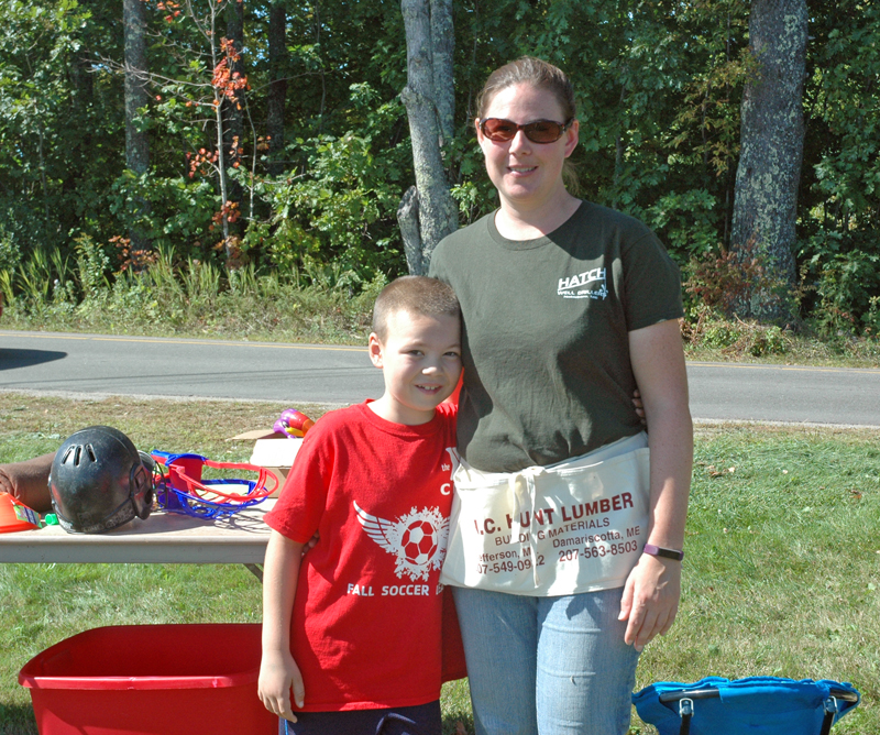 Elisha Hopkins and her 9-year-old son, Gage, of Nobleboro, man Gage's yard sale at Hatch Well Drillers on Saturday, Sept. 23. Gage held the yard sale to help people impacted by recent hurricanes. (Alexander Violo photo)