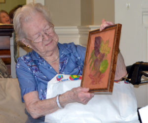 Elizabeth "Betty" Pierce admires a gift during her 100th birthday party at Chase Point Assisted Living in Damariscotta on Sept. 26. (Charlotte Boynton photo)