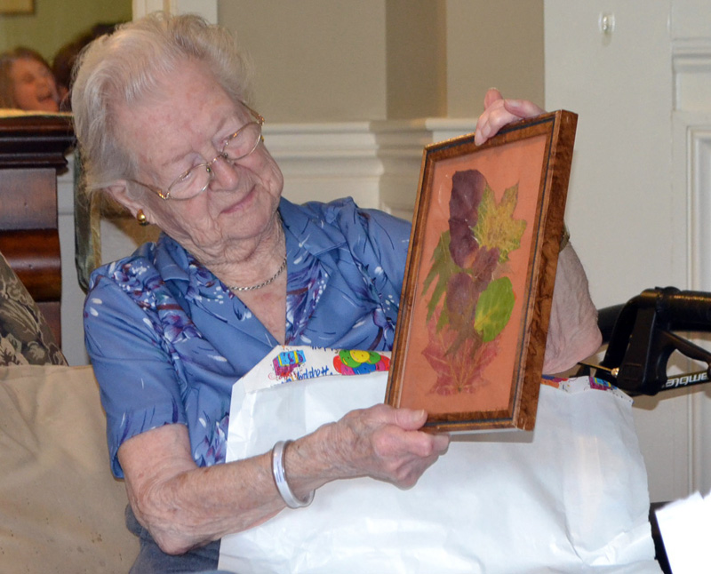 Elizabeth "Betty" Pierce admires a gift during her 100th birthday party at Chase Point Assisted Living in Damariscotta on Sept. 26. (Charlotte Boynton photo)