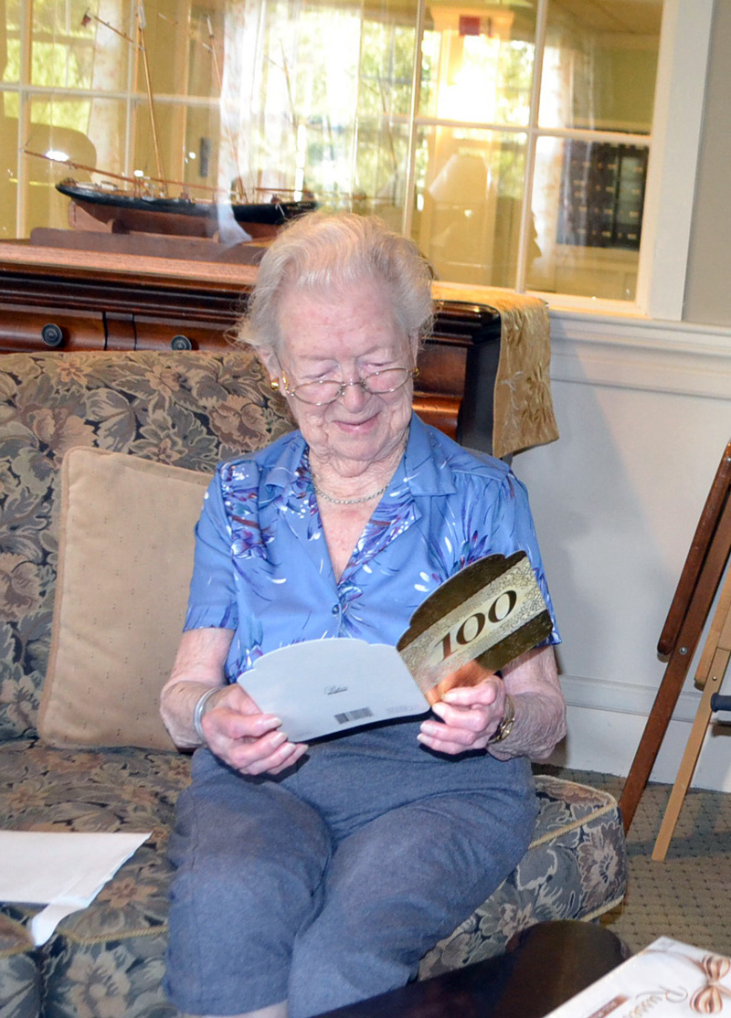 The county's newest centenarian, Elizabeth "Betty" Pierce, smiles as she reads a 100th birthday card from the staff of the Westport Island town office. (Charlotte Boynton photo)