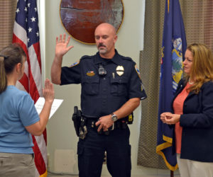 Wiscasset Town Clerk Linda Perry (left) administers the oath of office to Wiscasset Police Department Sgt. Craig Worster on Monday, Sept. 11 as Worster's fiancee, Dr. Margaret Marcone, looks on. (Abigail Adams photo)