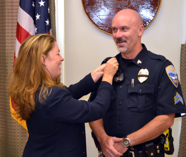 Dr. Margaret Marcone pins chevrons onto Wiscasset Police Department Sgt. Craig Worster's uniform during Worster's swearing-in ceremony Monday, Sept. 11. (Abigail Adams photo)