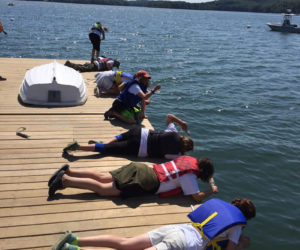 Boothbay Sea and Science Center campers take temperature, salinity and turbidity measurements with thermometers, hydrometers, and Secchi disks off the Darling Marine Center dock.