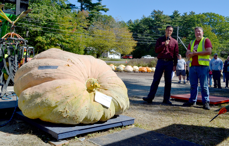 Charlie Lopresti (left) and Joseph Gaboury await the weight reveal of Gaboury's pumpkin during the Damariscotta Pumpkinfest's annual giant pumpkin weigh-off at Pinkham's Plantation on Sunday, Oct. 1. (Maia Zewert photo)