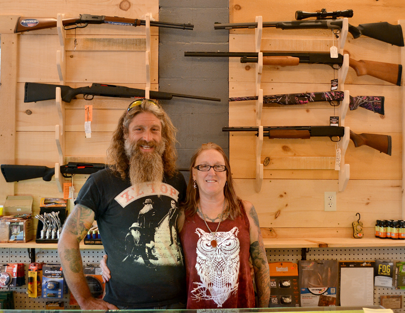 Dresden Take Out owners Mason and Kathy Dubord stand in front of a rack of firearms in the store's new gun room Tuesday, Oct. 10. (Maia Zewert photo)