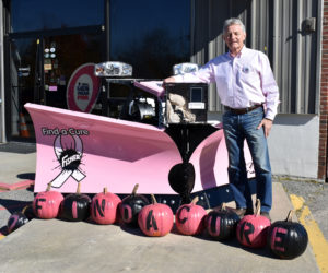 Randy Miller of Newcastle Chrysler Dodge Jeep Ram Viper stands at his dealership with a pink plow he is auctioning off.