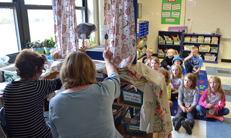 Great Salt Bay Community School second-grade teacher Lorna Fake and volunteer Marnie Sinclair perform a puppet show about seed transportation Thursday, Oct. 26. (Maia Zewert photo)