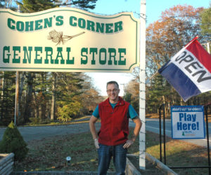 Ronald Cohen stands in front of the sign for Cohen's Corner General Store, now open on Route 27 in Edgecomb. (Alexander Violo photo)