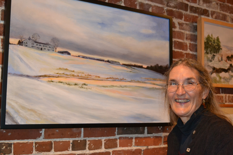 Artist Susan Parrish Carter poses next to "Spring Brook," her glazed oil-on-canvas painting currently on exhibit at Damariscotta River Grill. (Christine LaPado-Breglia photo)