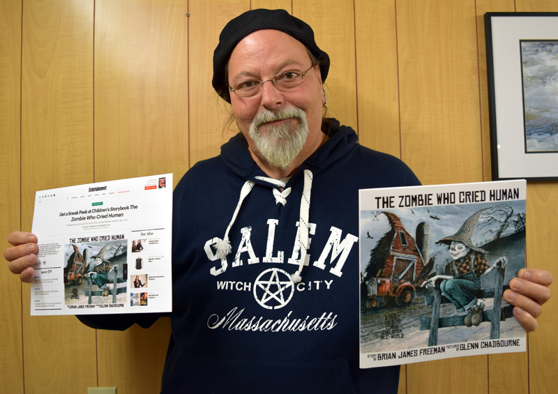 Newcastle artist Glenn Chadbourne holds a print-out of an Entertainment Weekly post about his forthcoming book (left) and an advance copy of the book, "The Zombie Who Cried Human."