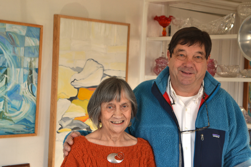 Round Pond artist Sally DeLorme Pedrick and gallery visitor Mark DesMeules stand before Pedrick's paintings "A Season of Chess" (left) and "North Wall" on Sunday, Dec. 3. (Christine LaPado-Breglia photo)