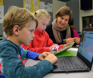 From left: Nathaniel Hufnagel and Fiona Duffy code as Nathaniel's mother, Liza Fleming-Ives, looks on at Great Salt Bay Community School in Damariscotta on Thursday, Dec. 7. (Maia Zewert photo)