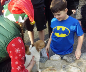 Volunteer elf Heather Straz delivers Rosie to her new human brother, Cameron Kirby, of Portland, in a 2015 Christmas delivery. (Photo courtesy Sean Kirby)