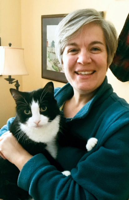 Trendy Stanchfield poses with her newest family member, Ermie the tuxedo cat, recently adopted from Coastal Humane Society. Stanchfield will serve as the organizationÂ’s new executive director starting Tuesday, Jan. 2.