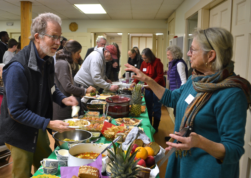 Neighbors George Mason and Paula Christensen, of Nobleboro, greet each other during a potluck at The Second Congregational Church in Newcastle on Martin Luther King Jr. Day. (Maia Zewert photo)