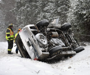 Waldoboro firefighters work at the scene of a rollover on Route 1. Emergency responders extricated two of the vehicle's four occupants. (Alexander Violo photo)