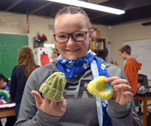 Whitefield Elementary School eighth-grader Miranda Northrup displays two of the tiny hats created by local volunteers for the Whitefield National Junior Honor Society's Preemie Project. (Christine LaPado-Breglia photo)