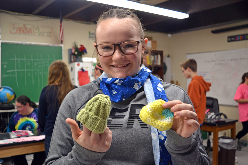 Whitefield Elementary School eighth-grader Miranda Northrup displays two of the tiny hats created by local volunteers for the Whitefield National Junior Honor Society's Preemie Project. (Christine LaPado-Breglia photo)