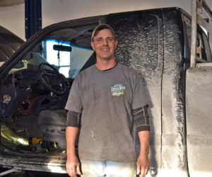 Larry Eckert, owner of FIX Marine, Truck, and Auto, takes a break from installing a new heater core in a Dodge Ram at his new business in Wiscasset. (Charlotte Boynton photo)