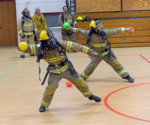 Ken Ripley and Garrett Joslyn throw in unison during a Whitefield Fire Department Scott Air Pack training exercise on Monday. (Paula Roberts photo)