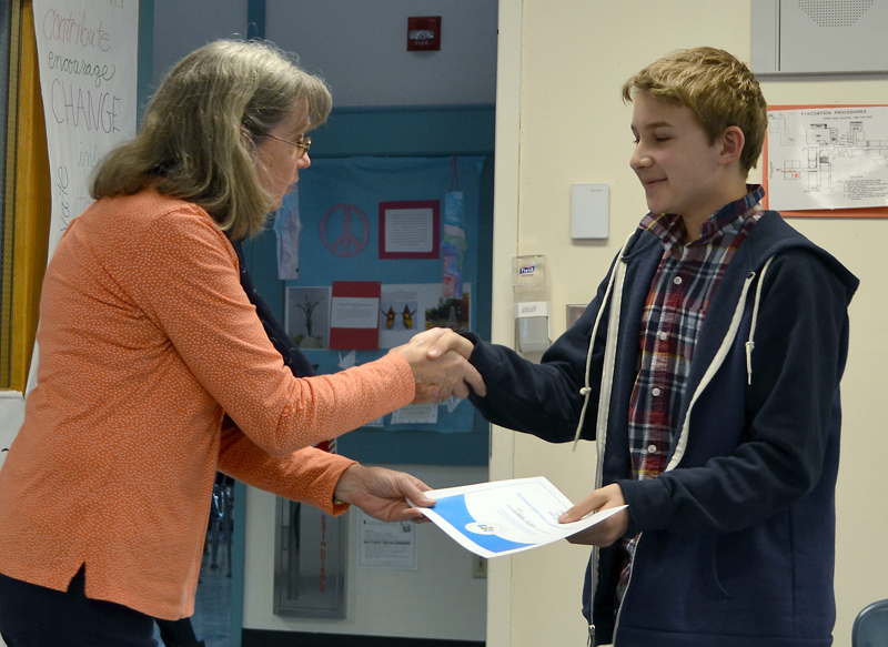Lincoln County Spelling Bee moderator and Bristol Consolidated School teacher Becky Cooper presents Isaac Wyer with a certificate for winning the bee Thursday, Feb. 8. (Maia Zewert photo)