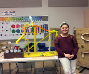 Kammie Thompson poses with a Rube Goldberg machine made in Mrs. Cunningham's fourth grade class.
