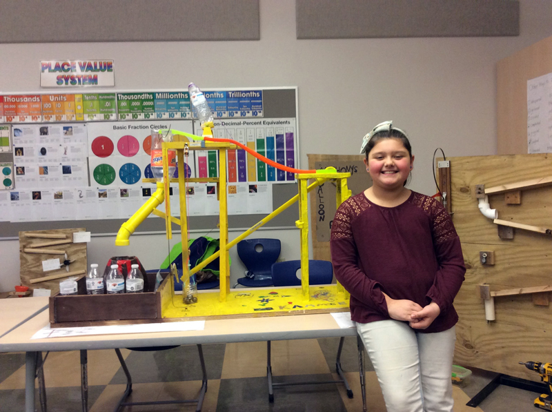 Kammie Thompson poses with a Rube Goldberg machine made in Mrs. Cunningham's fourth grade class.