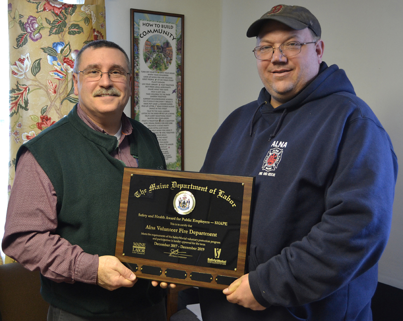 Alna Fire Chief Mike Trask (right) accepts the Safety and Health Award for Public Employers from Michael LaPlante, of the Maine Department of Labor, during the Alna Board of Selectman's meeting Wednesday, March 14. (Maia Zewert photo)