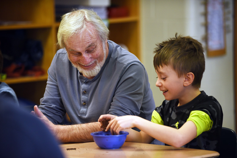 David Caron and 8-year-old Mason Read roll soil into a ball during a seed bomb-making workshop at Great Salt Bay Community School. (Jessica Picard photo)