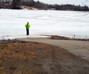 Clary Lake property owner George Fergusson stands on the ice at the boat ramp in Jefferson to show the lake's low water level. (Greg Foster photo)