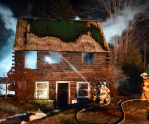 Firefighters attempt to extinguish a blaze at a two-story log cabin at 526 Upper Round Pond Road in Bristol late Sunday, April 15. (J.W. Oliver photo)