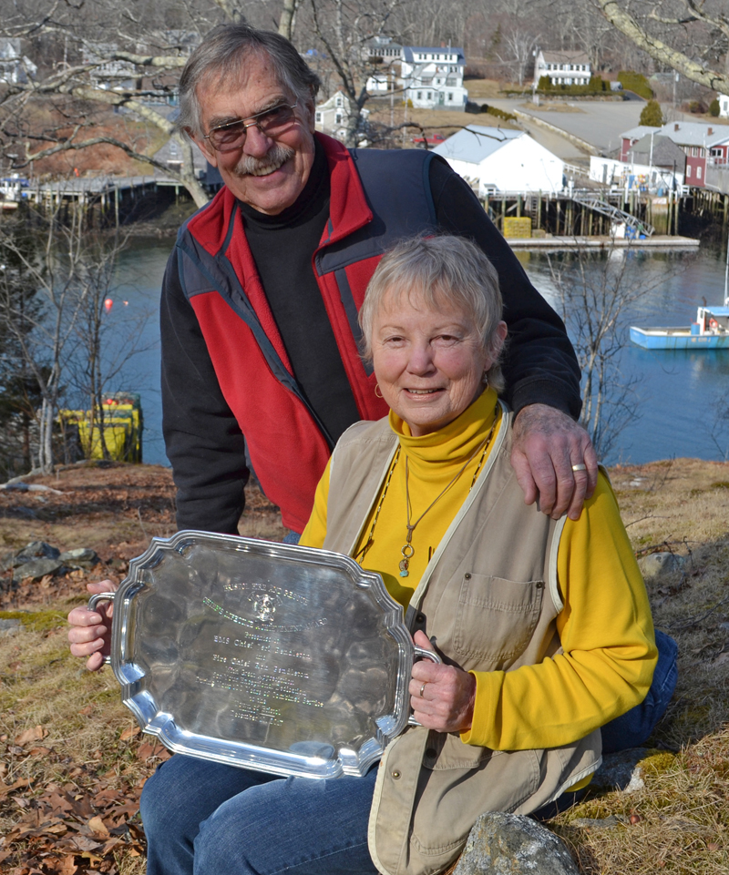 Ron and Jeri Pendleton pose for a photo outside their New Harbor home with a silver platter, a gift in recognition of their 100 years of service to Bristol Fire and Rescue. (Maia Zewert photo)