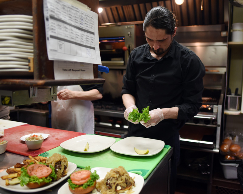 Chef Zack Wiggins prepares food in the kitchen of King Eider's Pub on Monday, April 2. (Jessica Picard photo)