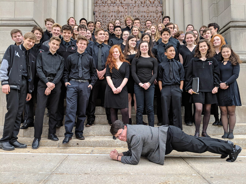 The Lincoln Academy Wind Ensemble on the steps of Riverside Church in New York City, with band director Liz Matta showing off her plank.