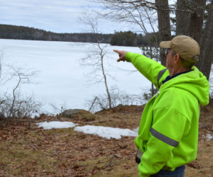 Clary Lake property owner George Fergusson points to his view of the lake in March. The Clary Lake Association is raising money to purchase the Clary Lake Dam and restore the lake's historical water level. (Greg Foster photo, LCN file)