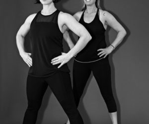 Coaches Darcy Fraser (left) and Virginia Shaw demonstrate the side split on Pilates Reformers.