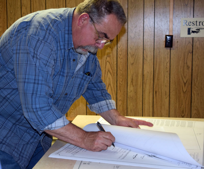 Edgecomb Planning Board alternate Dave Boucher signs the application for a new pub due to open on Route 27. (Jessica Clifford photo)