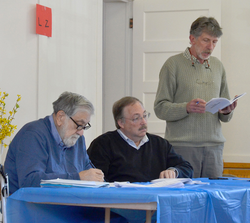 Edgecomb Selectman Mike Smith (right) reads from the town report as Selectmen Jack Sarmanian (left) and Ted Hugger look on during the annual town meeting Saturday, May 19. (Jessica Clifford photo)