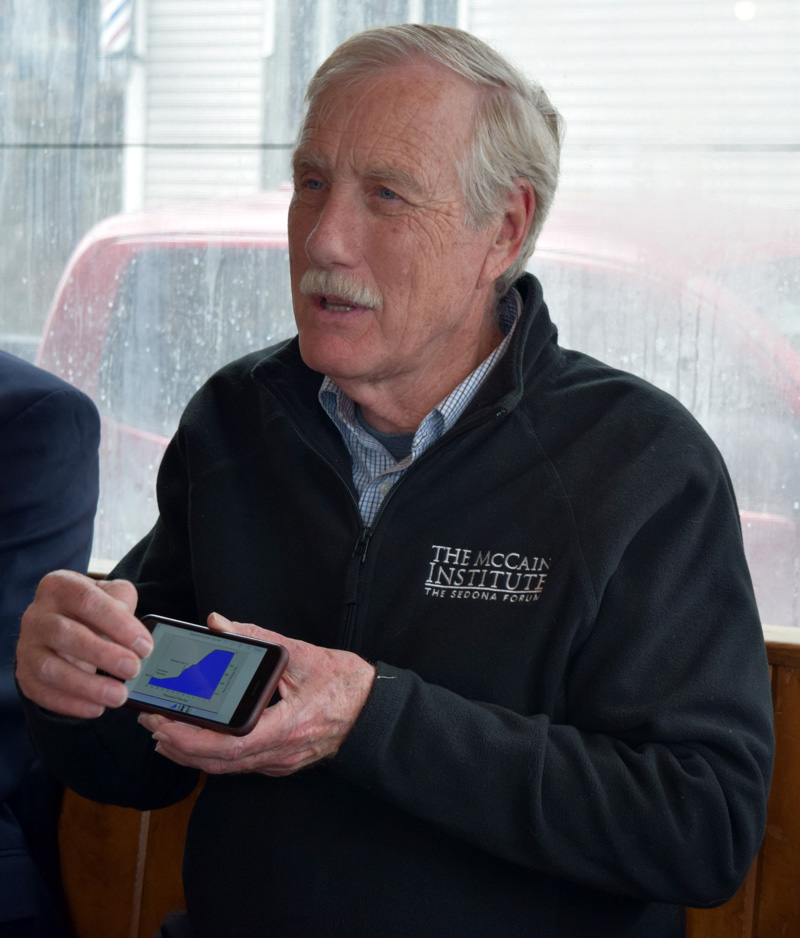 U.S. Sen. Angus King shows local officials a graph on his smartphone during a meeting about coastal resiliency at Sarah's Cafe in Wiscasset on Friday, April 27. (J.W. Oliver photo)