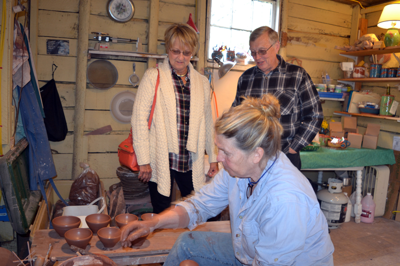 Cindy and Bill Anderson, who split their time between Palm Coast, Fla. and Spruce Head, watch as Libbey Seigars demonstrates the Japanese pottery-making style of "throwing from the mound" at Whitefield Pottery on Sunday, May 6 during the Maine Pottery Tour. (Christine LaPado-Breglia photo)