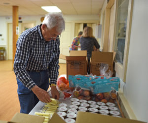 Gordon Davis, a member of the Rotary Club of Damariscotta-Newcastle, sets snacks out for the Ecumenical Food Pantry's backpack program Friday, May 25. (Jessica Picard photo)