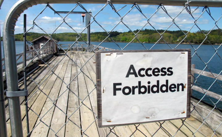 A fence blocks access to an aging pier at the University of Maine's Darling Marine Center, on the Damariscotta River in Walpole. (Bill Trotter photo/Bangor Daily News)