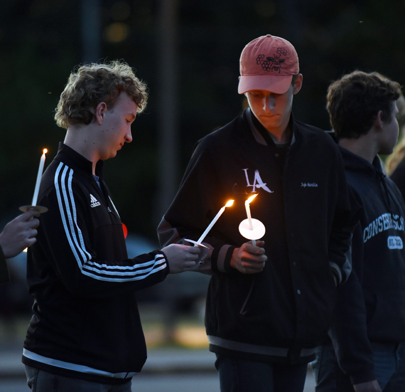 Lincoln Academy senior Will Shaffer (left) and junior Jojo Martin light candles at a vigil for Isabelle Manahan at Great Salt Bay Community School in Damariscotta on Monday, June 11. (Jessica Picard photo)
