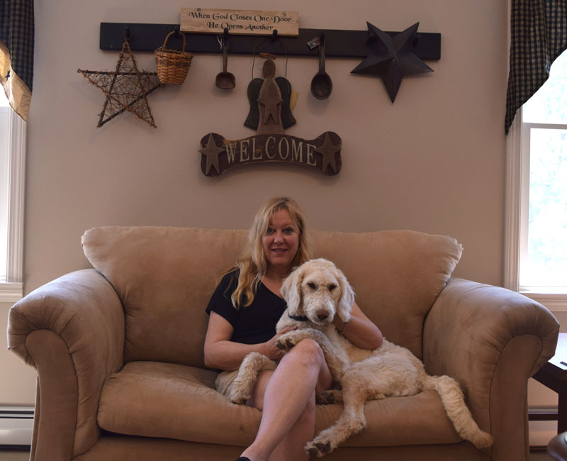 Freedom Center Director Jan Burns sits with her dog, Sophie, in the center's gathering room. (Jessica Clifford photo)