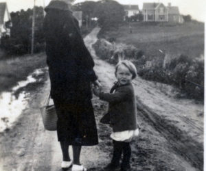 A young Dan Thompson, with neighbor Grace Howard, walks down Southside Road in New Harbor toward home, ca. 1920. (Photo courtesy Merle Thompson)